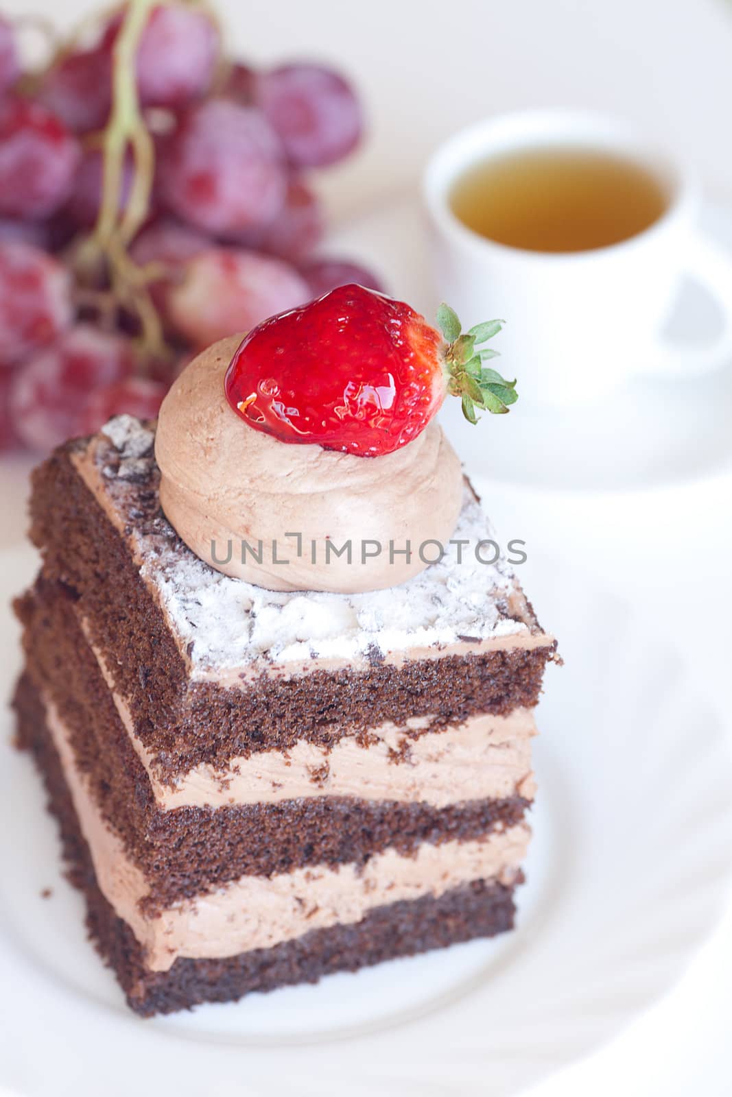 beautiful cake with strawberry,grapes and tea on a white backgro by jannyjus