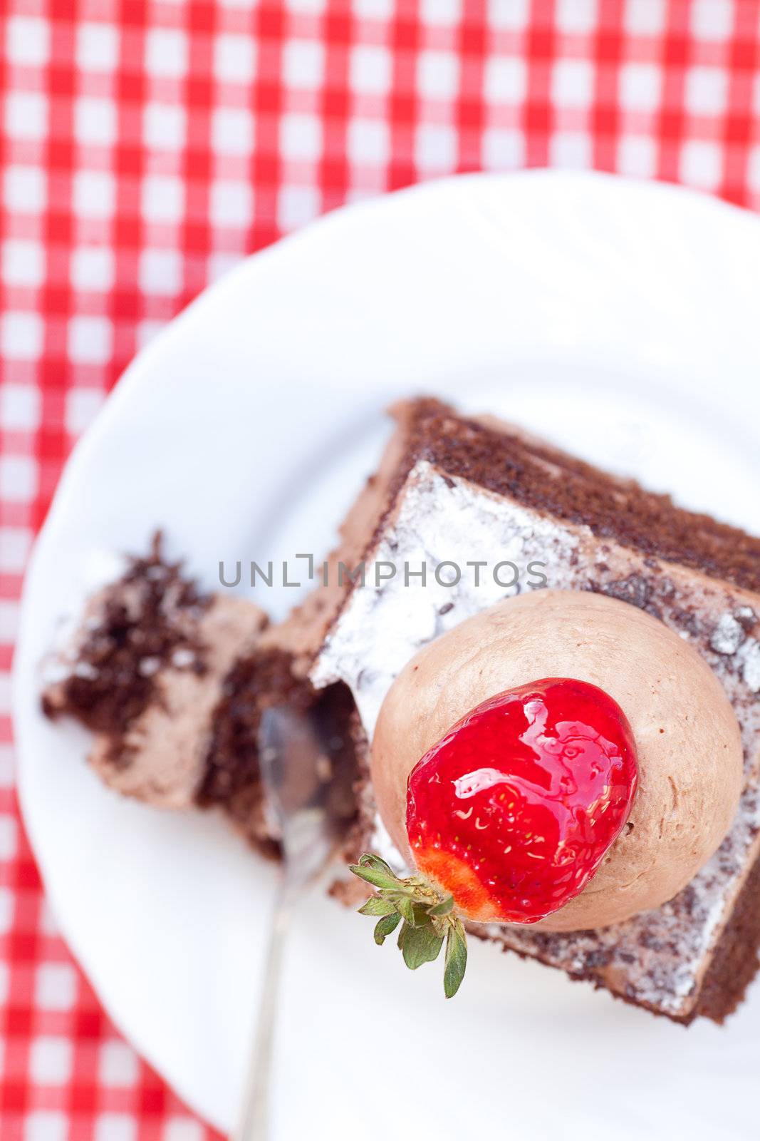 beautiful cake with strawberry on plaid fabric