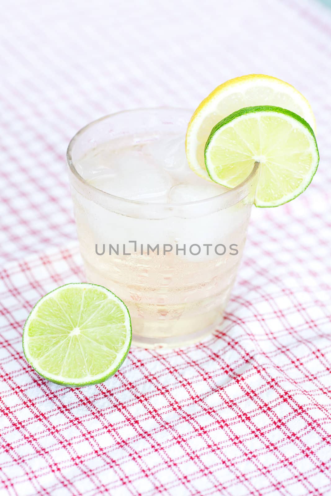 water with lemon and lime in a glass with ice by jannyjus
