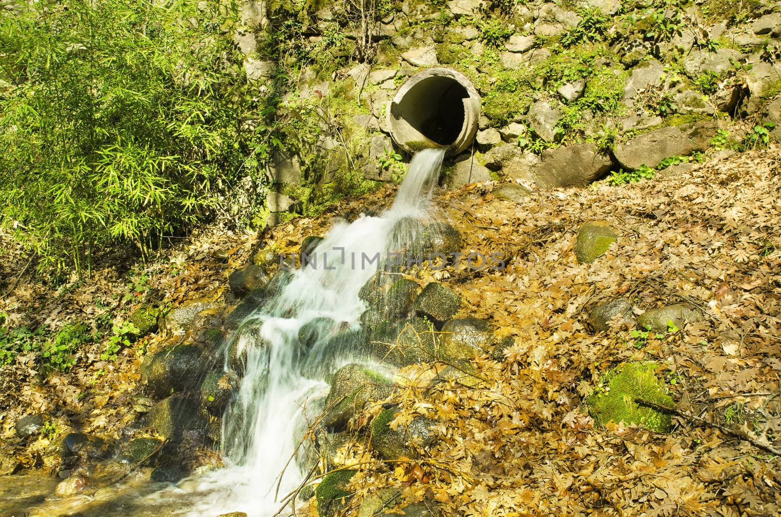 Clean water flowing from a pipe. by HERRAEZ