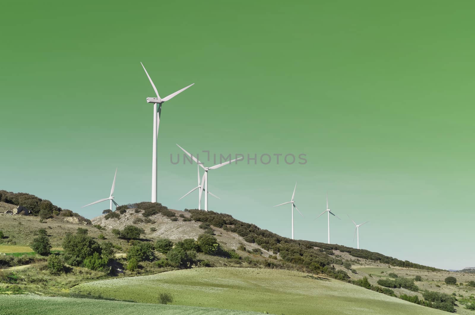  Wind turbines over Green background. Clean energy concept.