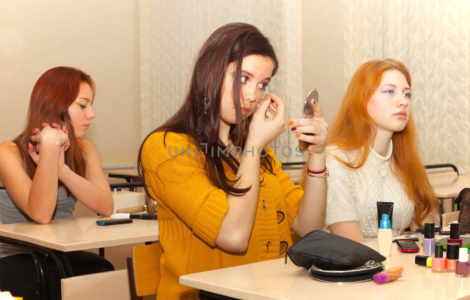 girls in the classroom during recess apply makeup