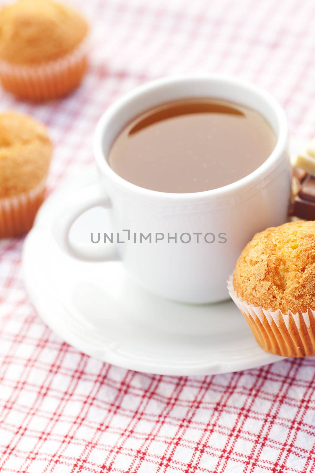 bar of chocolate,tea and muffin on plaid fabric