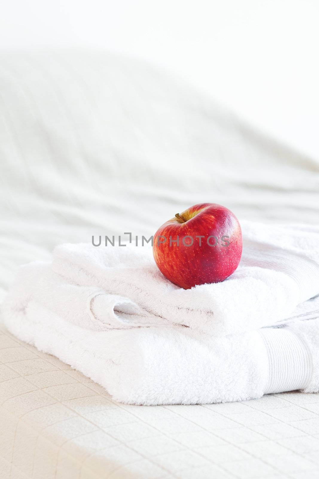 apple lying on towels on the bed  by jannyjus