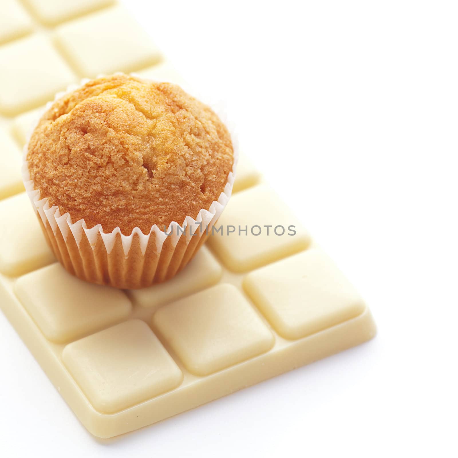 bar of white chocolate and muffin isolated on white