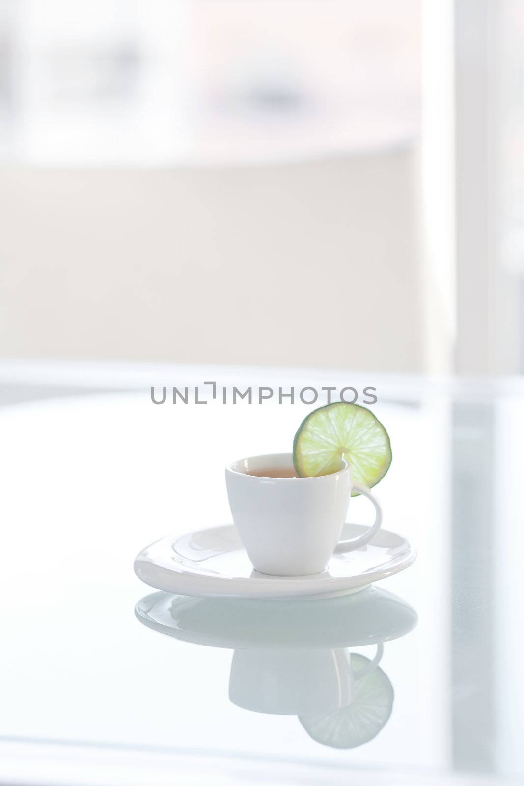 cup of tea with lemon on a glass surface by jannyjus