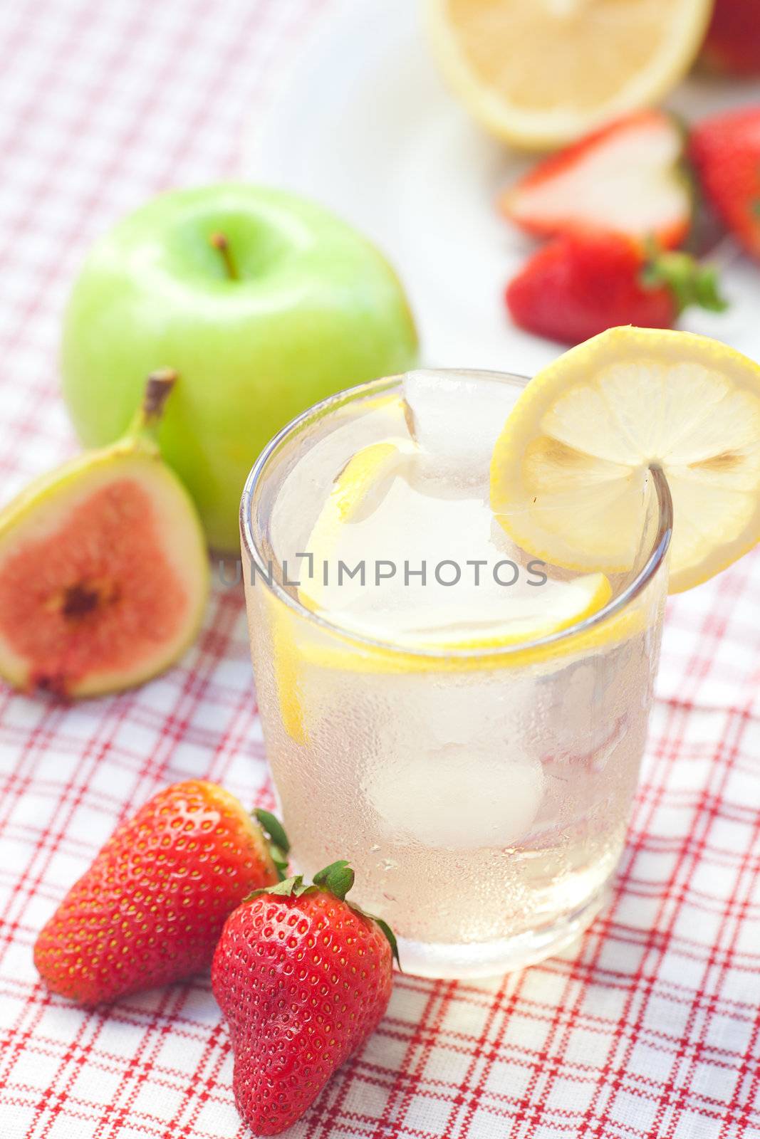 cocktail with ice,lemon, fig and strawberries on a plate by jannyjus