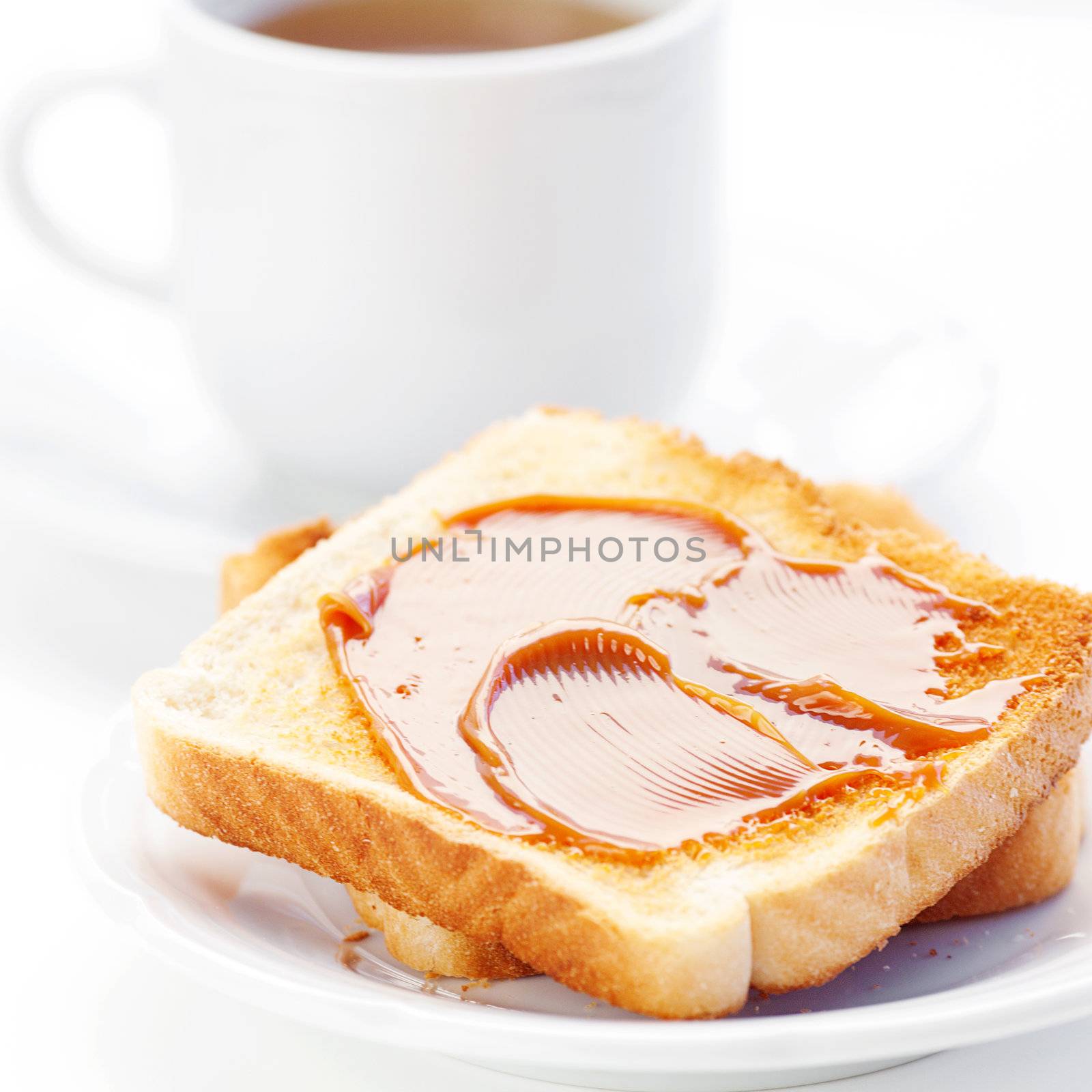 tea and toast with caramel isolated on white