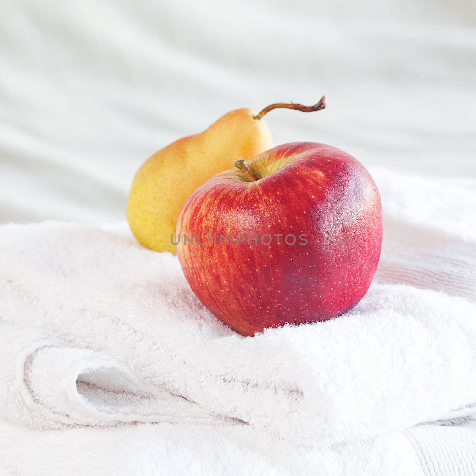 apple and pear on towels on the bed  by jannyjus