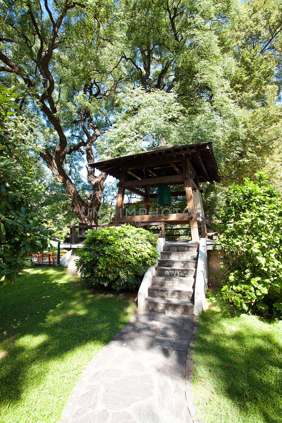 Japanese bell in the background of green trees by jannyjus