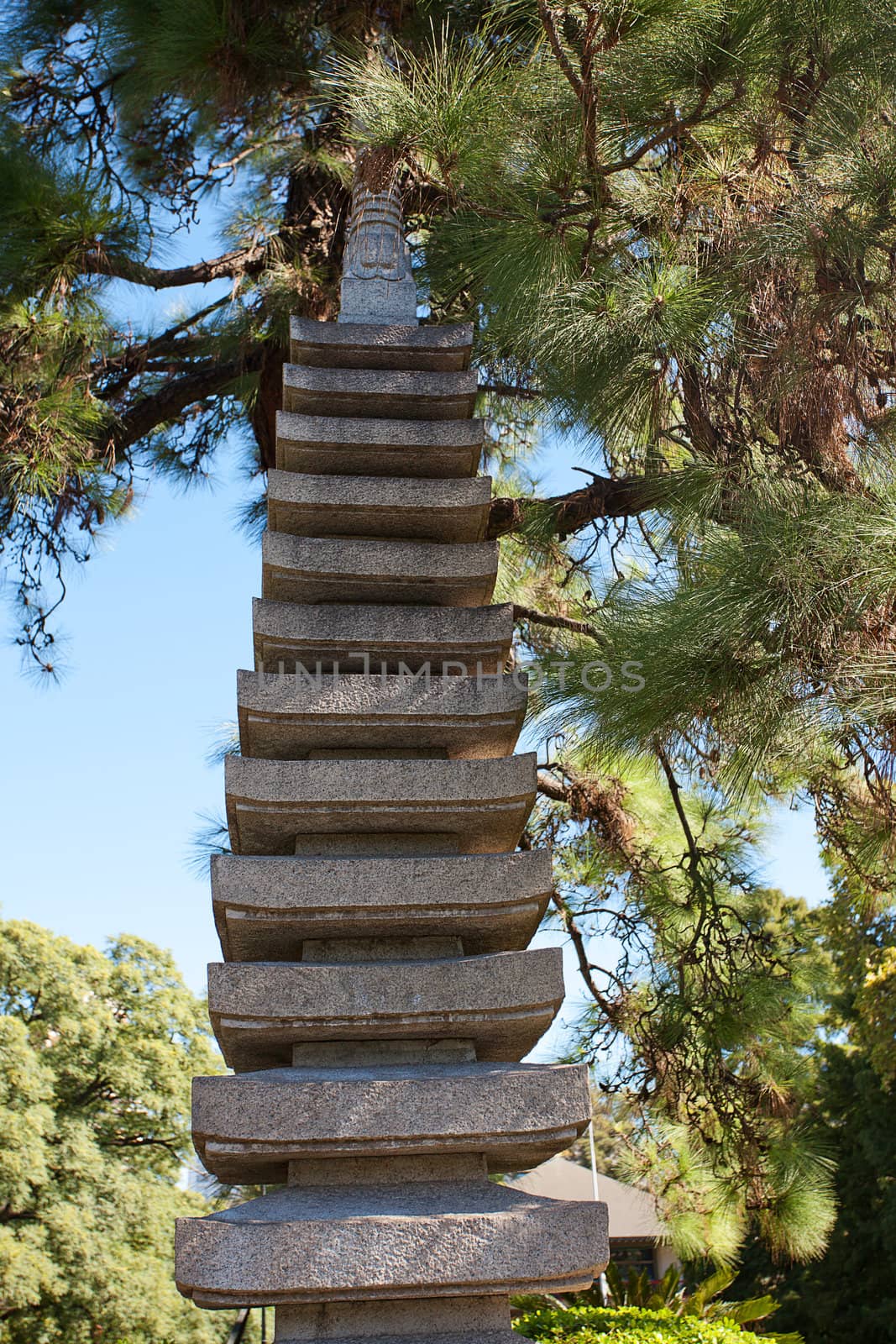 stone pagoda on the background of green trees by jannyjus