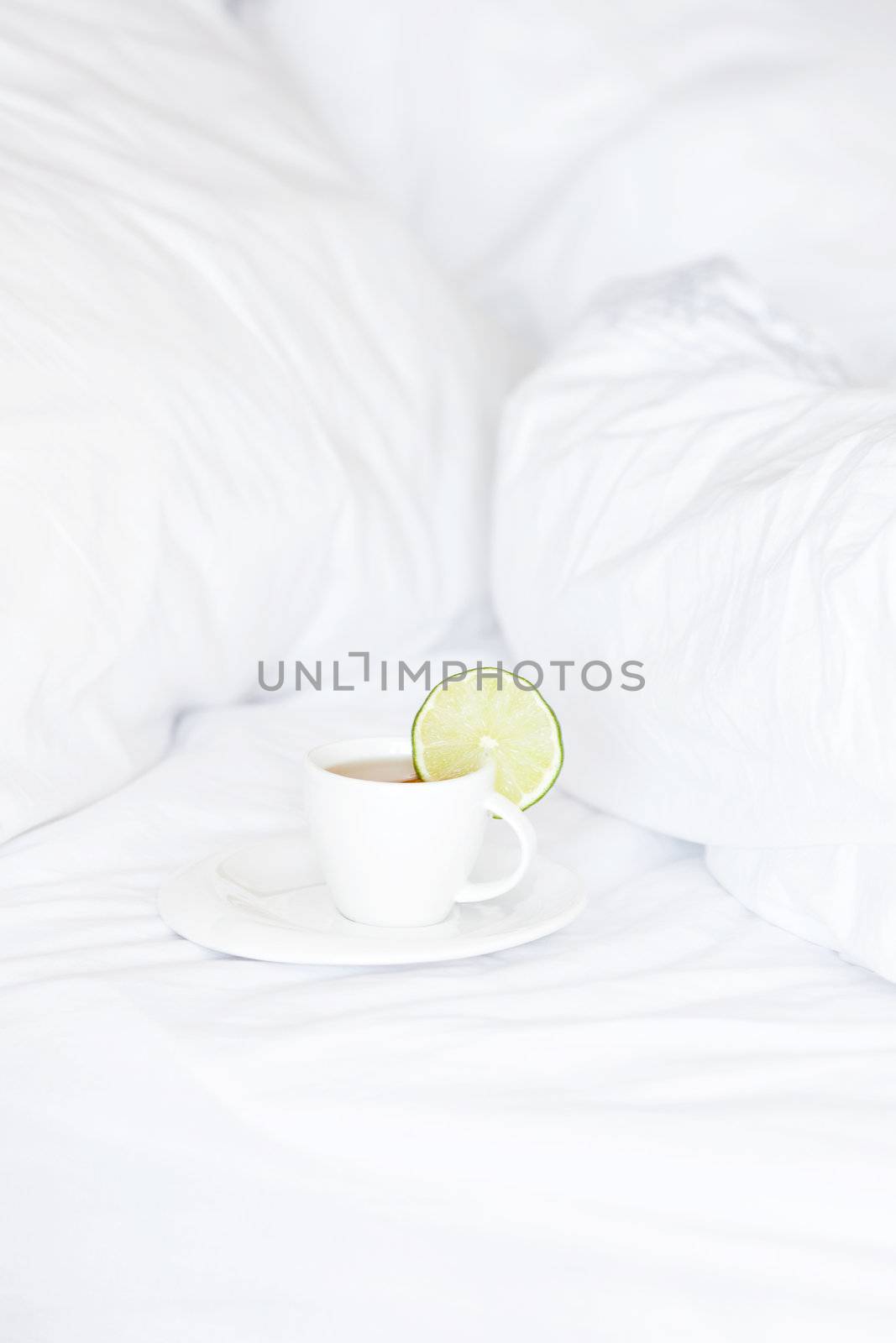 bed with a pillow and a cup of tea 