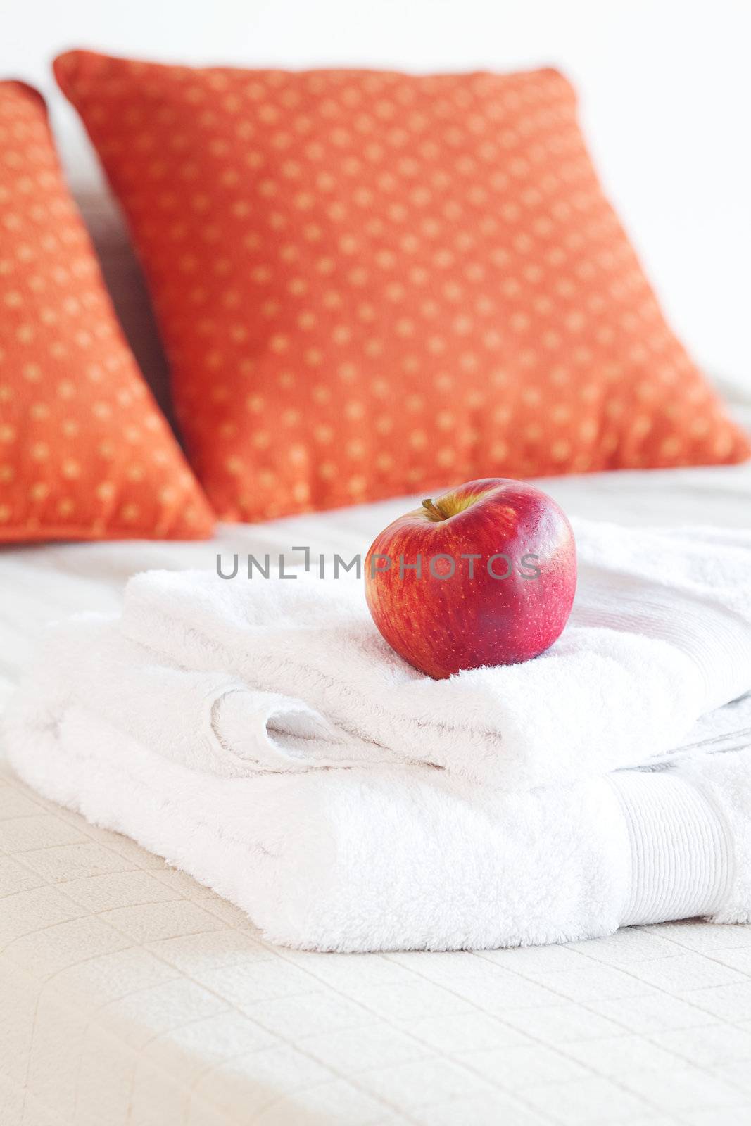 apple and white towels on the bed