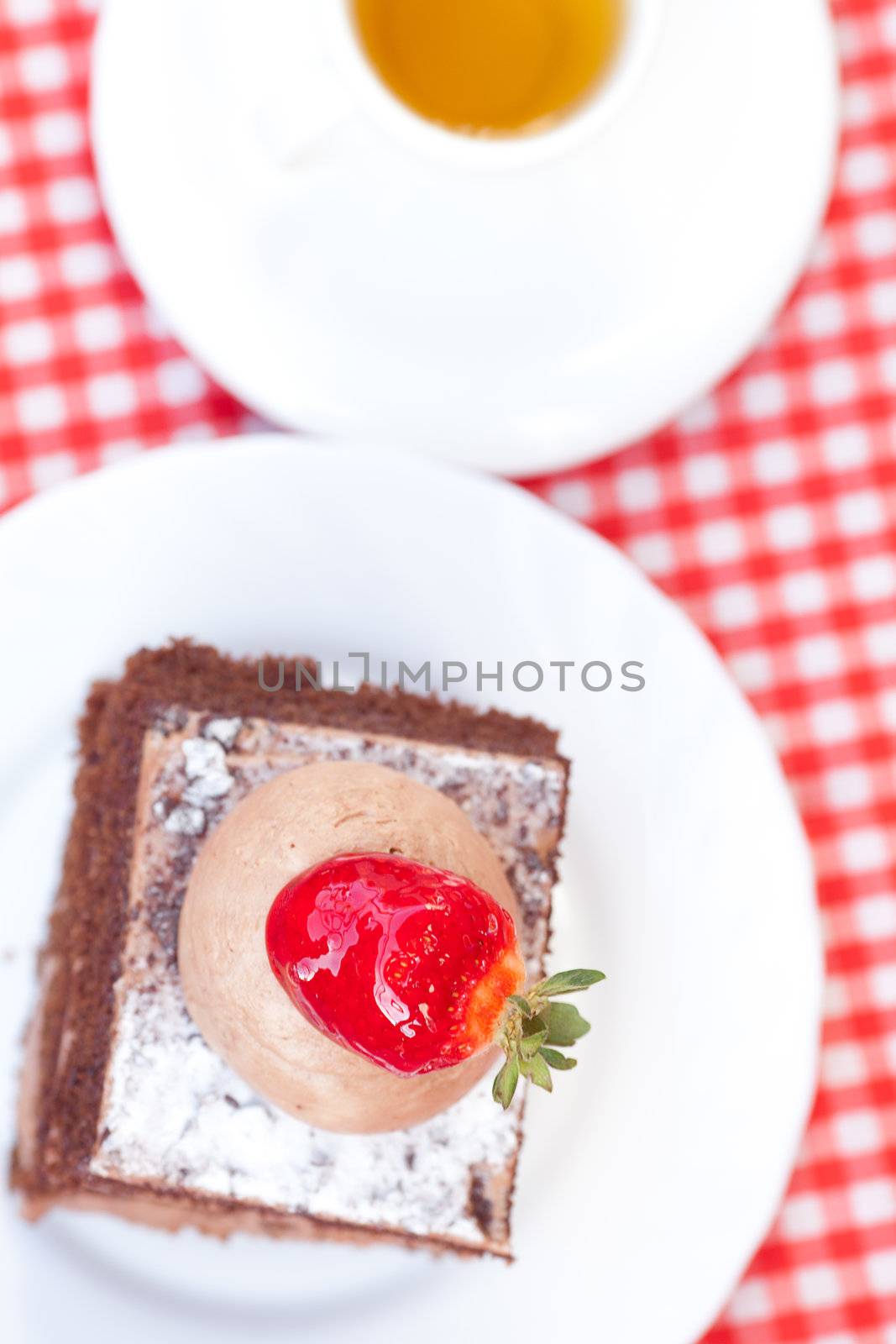 beautiful cake with strawberry and tea on plaid fabric by jannyjus