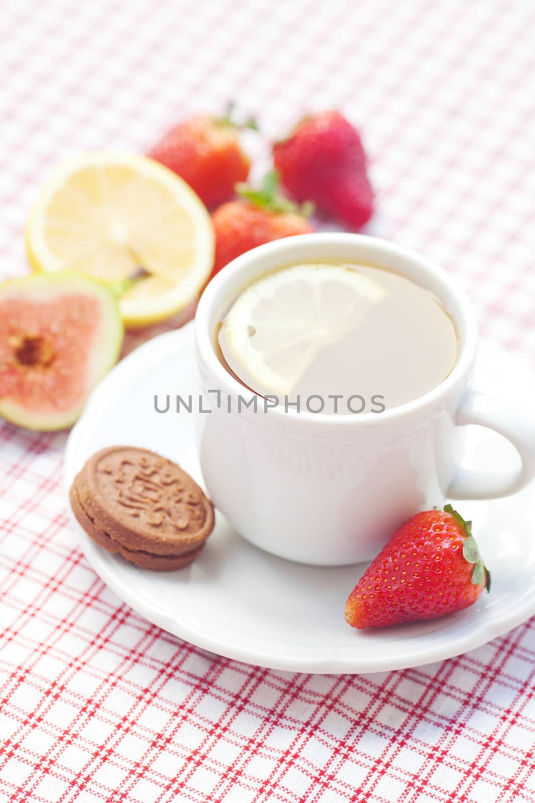 cup of tea,cookie, fig and strawberries on a plate by jannyjus