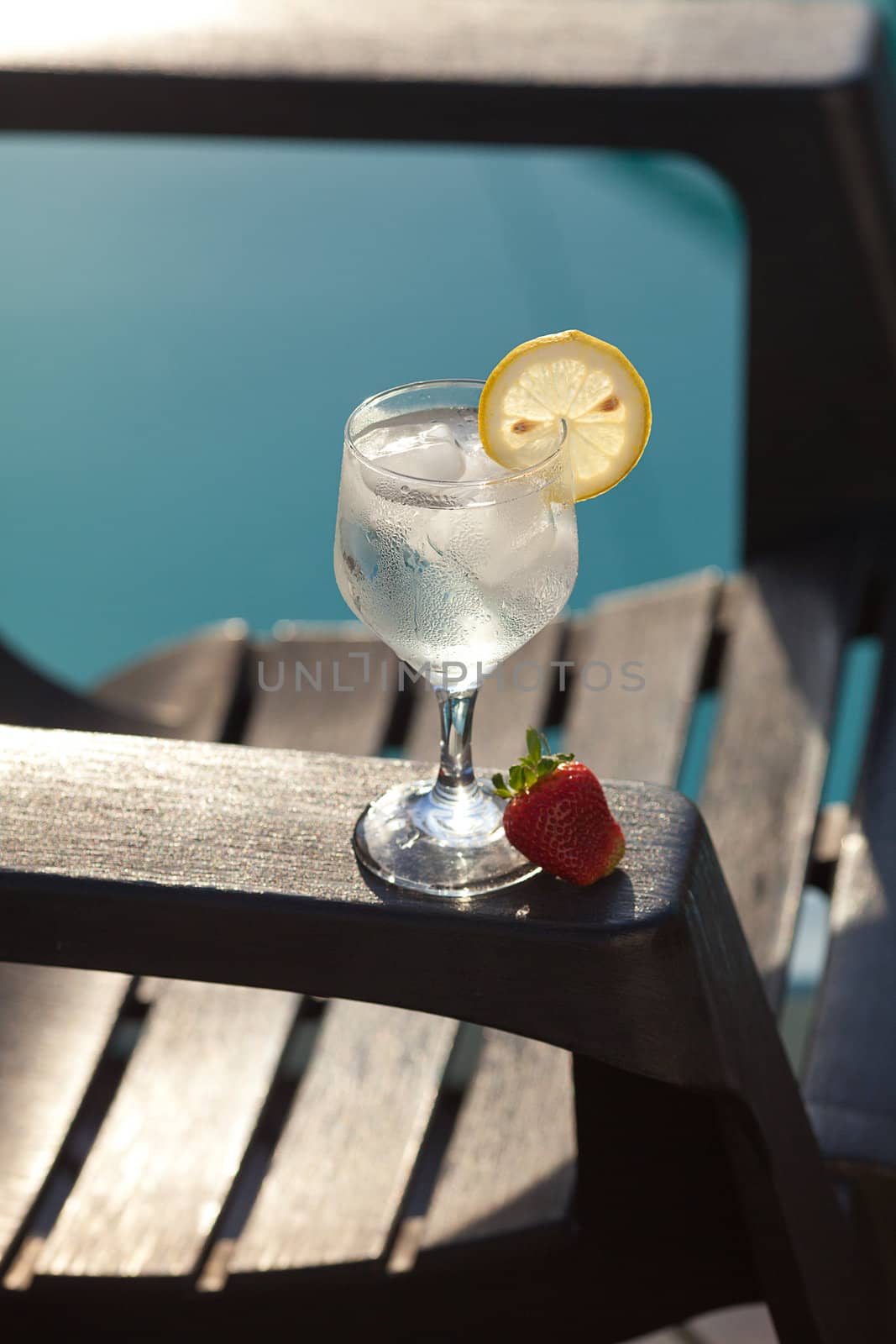 Swimming pool, lounge, a wine glass with ice, lemon and strawber by jannyjus