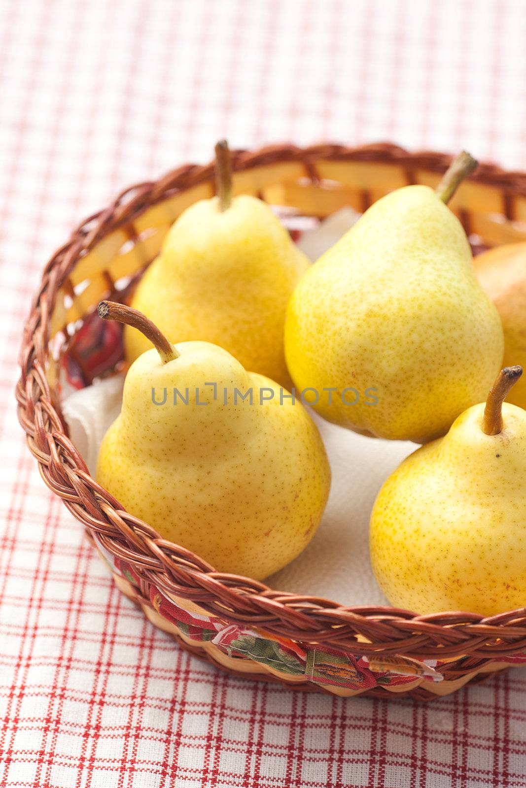 pears in a wooden basket  lying on a plaid fabric  by jannyjus