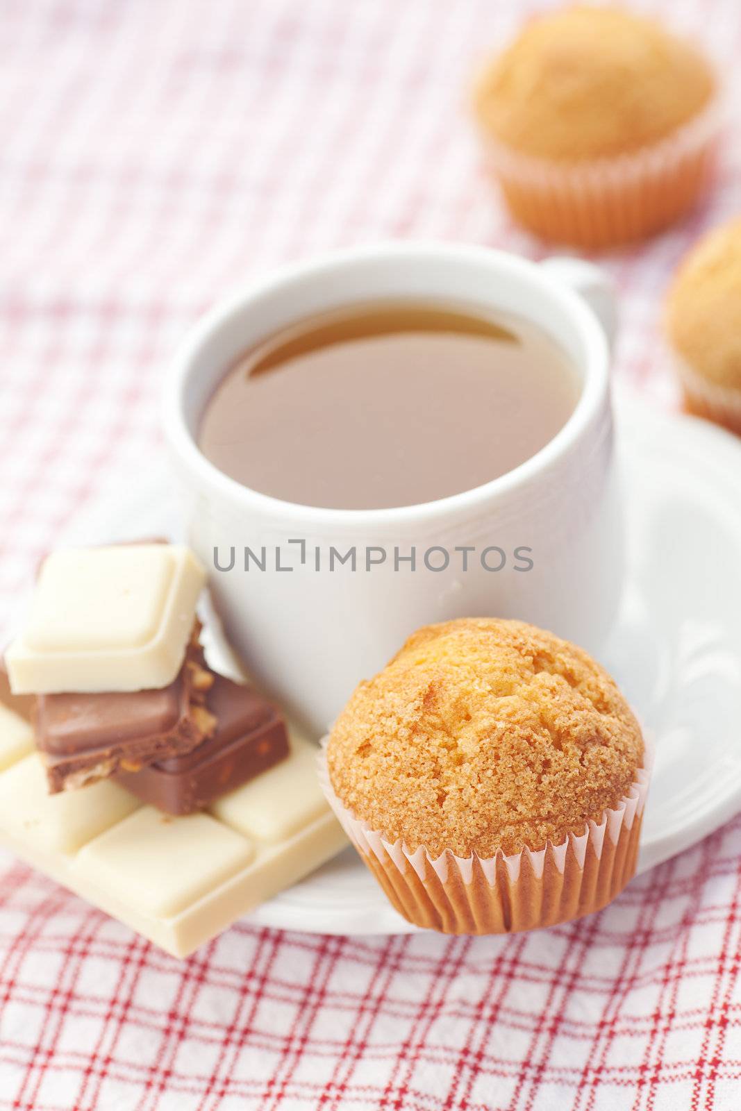 bar of chocolate,tea and muffin on plaid fabric