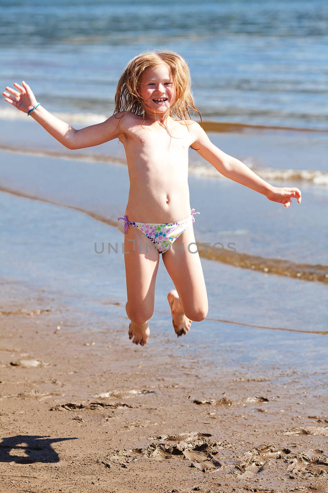 beautiful little girl jumping on the beach