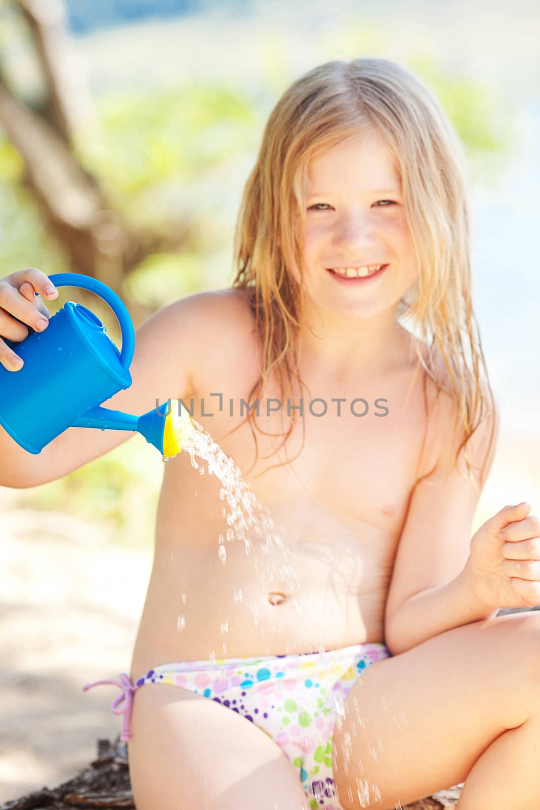 portrait of a beautiful little girl with a watering can by jannyjus