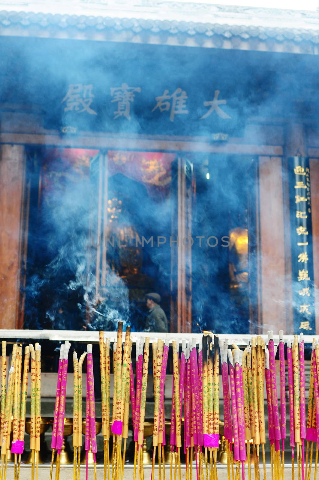 Burning incense sticks in front of a traditional Chinese ancient temple