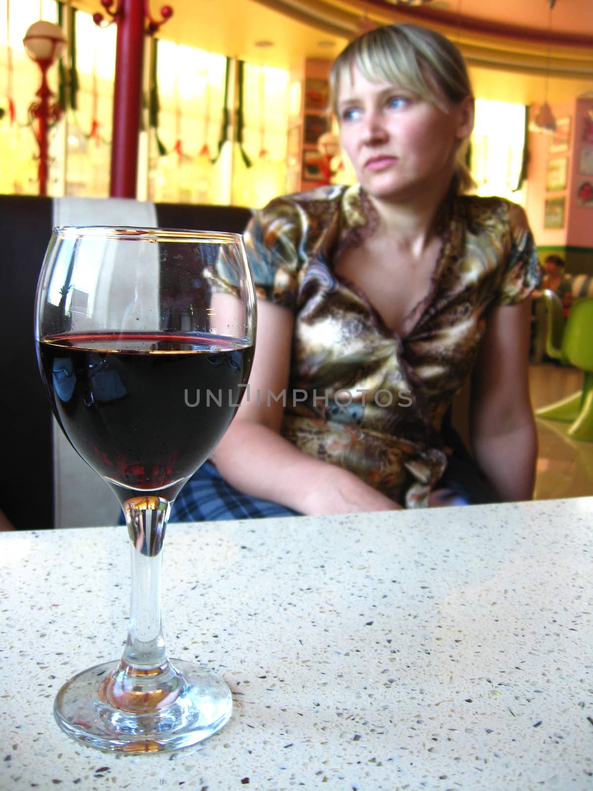 glass of red wine on the table and a girl