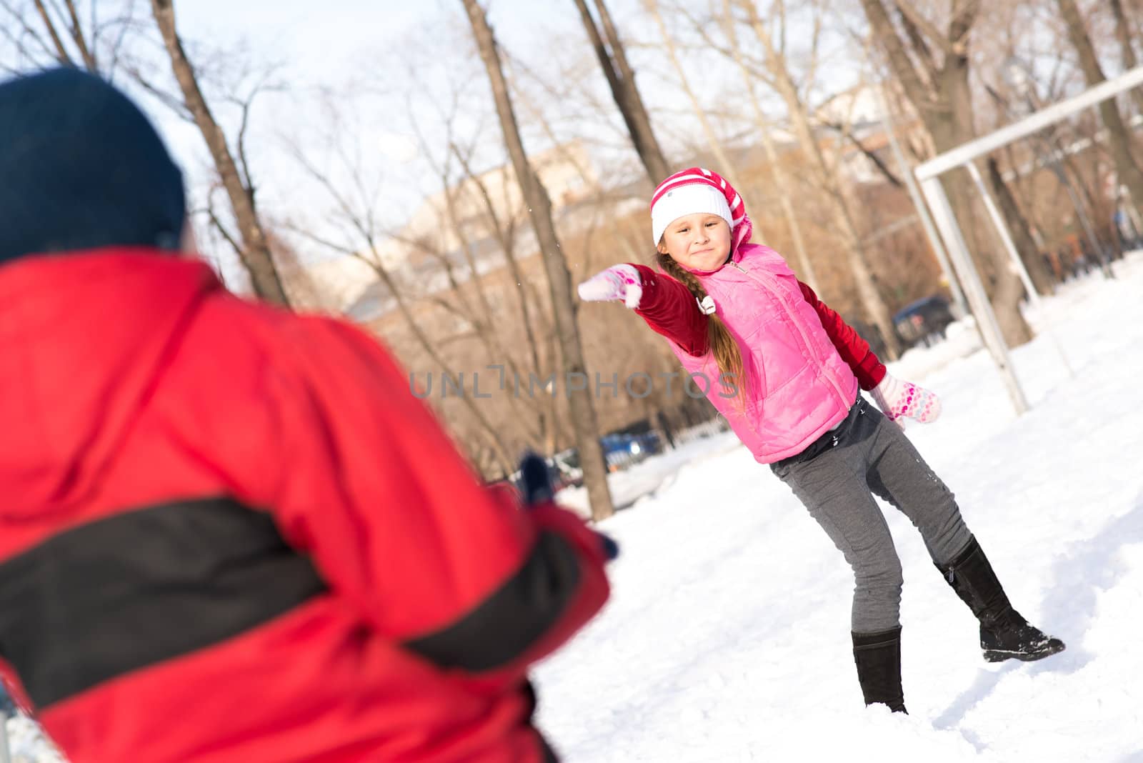 Children in Winter Park playing snowballs by adam121