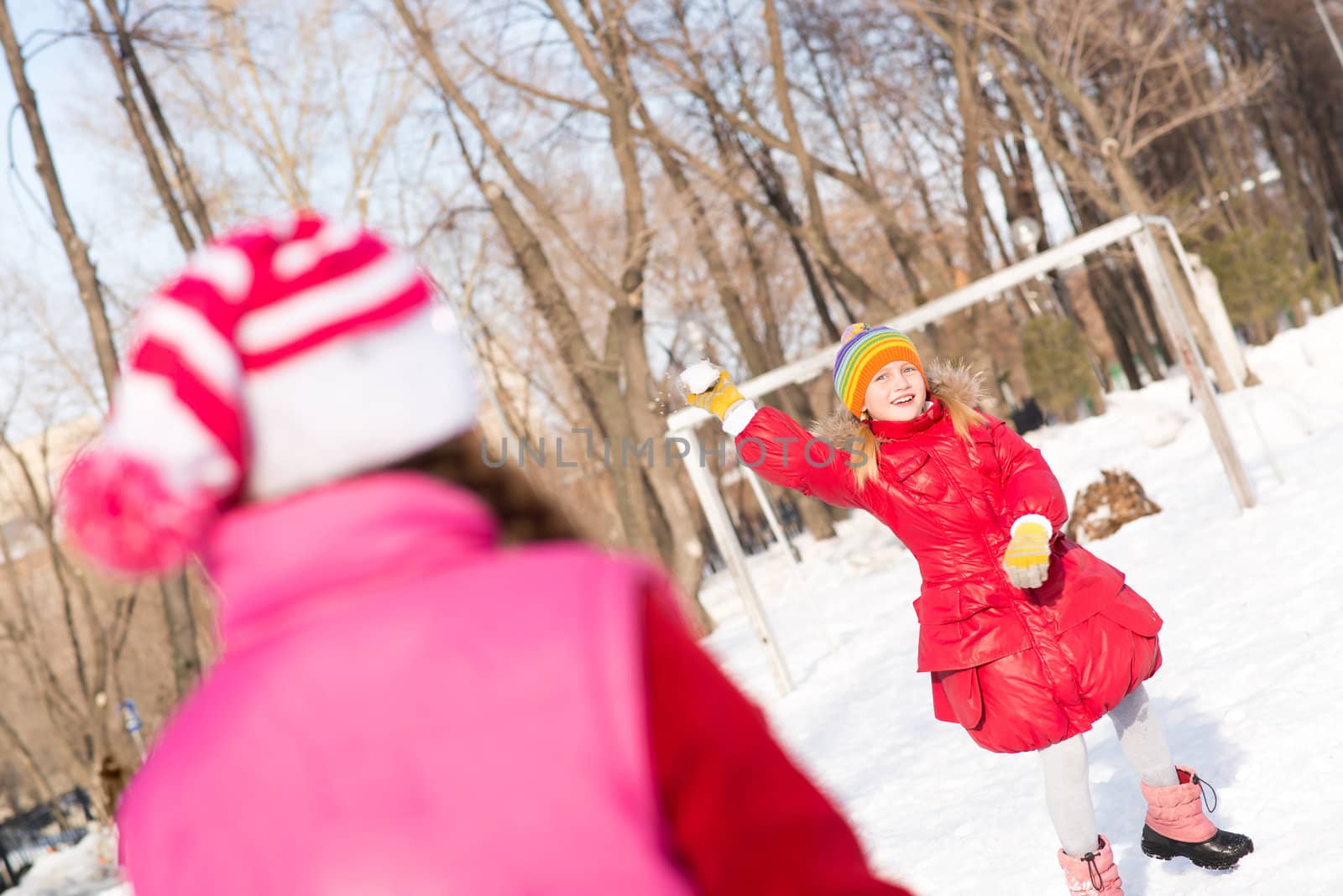 Children in Winter Park playing snowballs by adam121