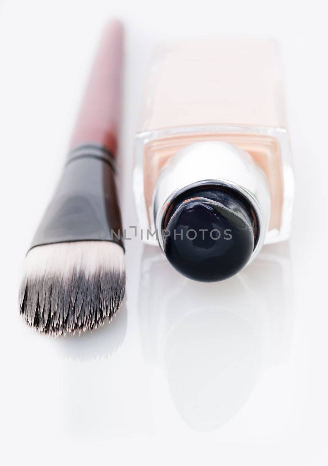 Cosmetic liquid foundation and brush on white by iryna_rasko