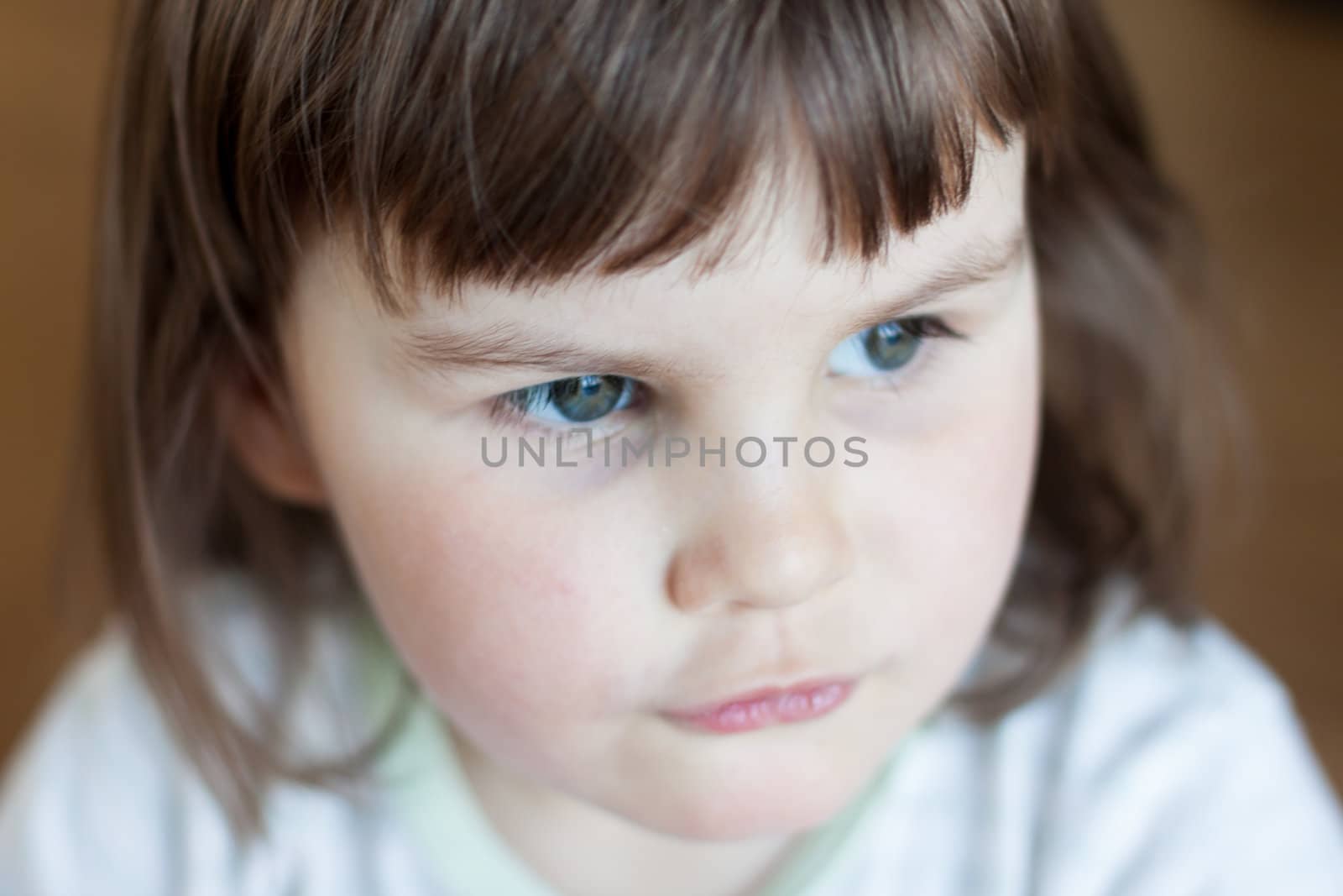 Closeup of a baby girl on the floor and looking away