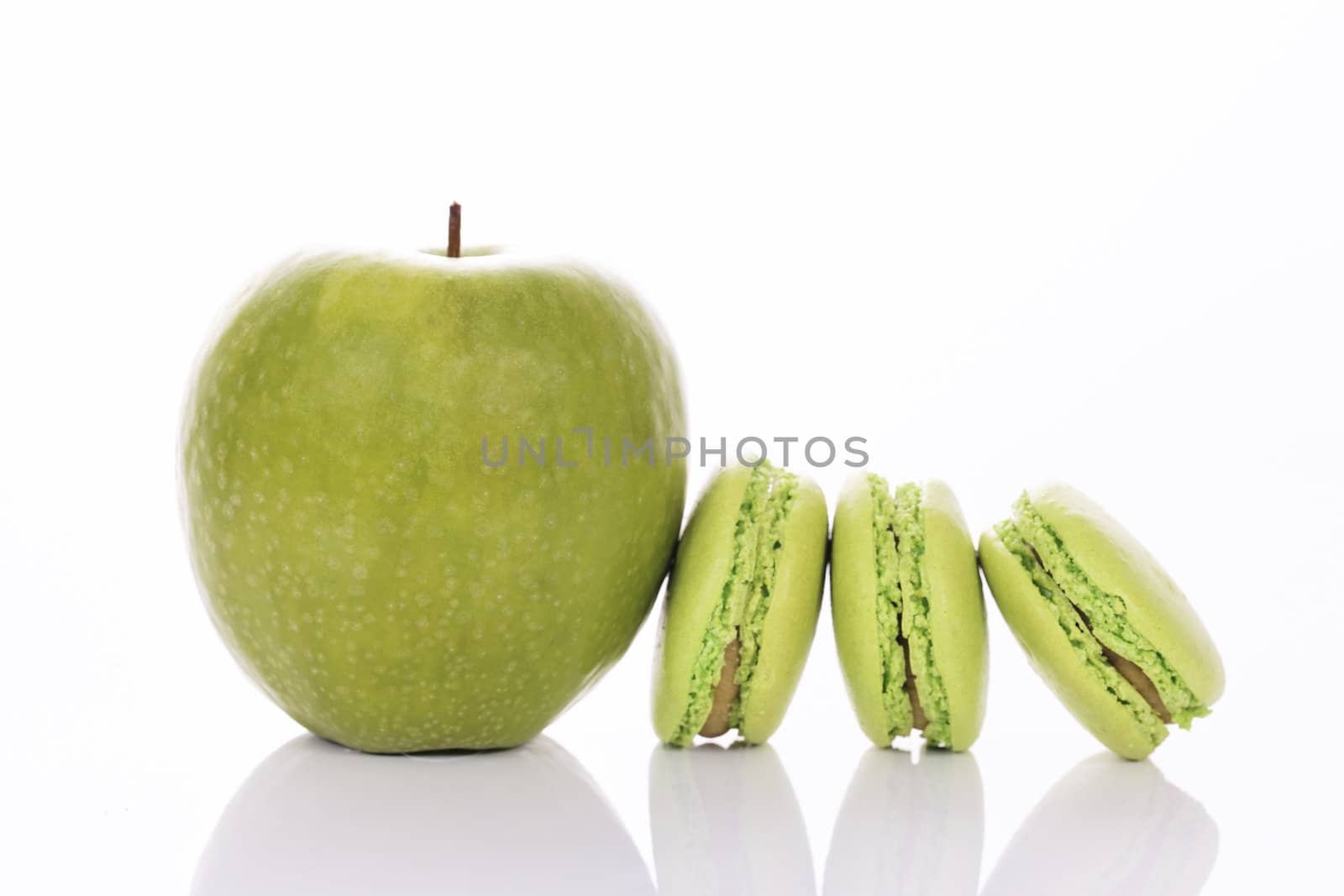 green apple with macaroons on white background