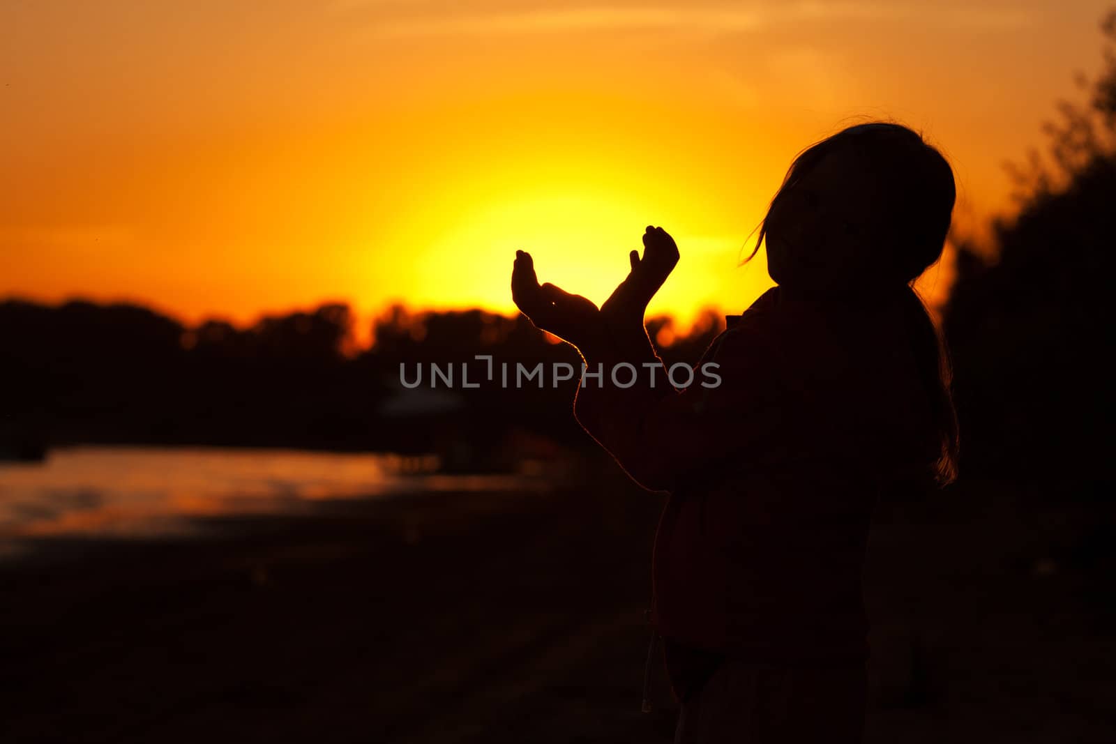 little girl holding in hands the setting sun by jannyjus