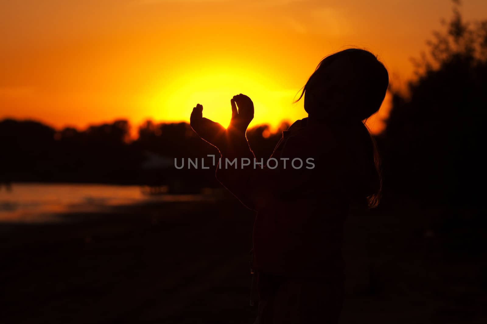 little girl holding in hands the setting sun by jannyjus