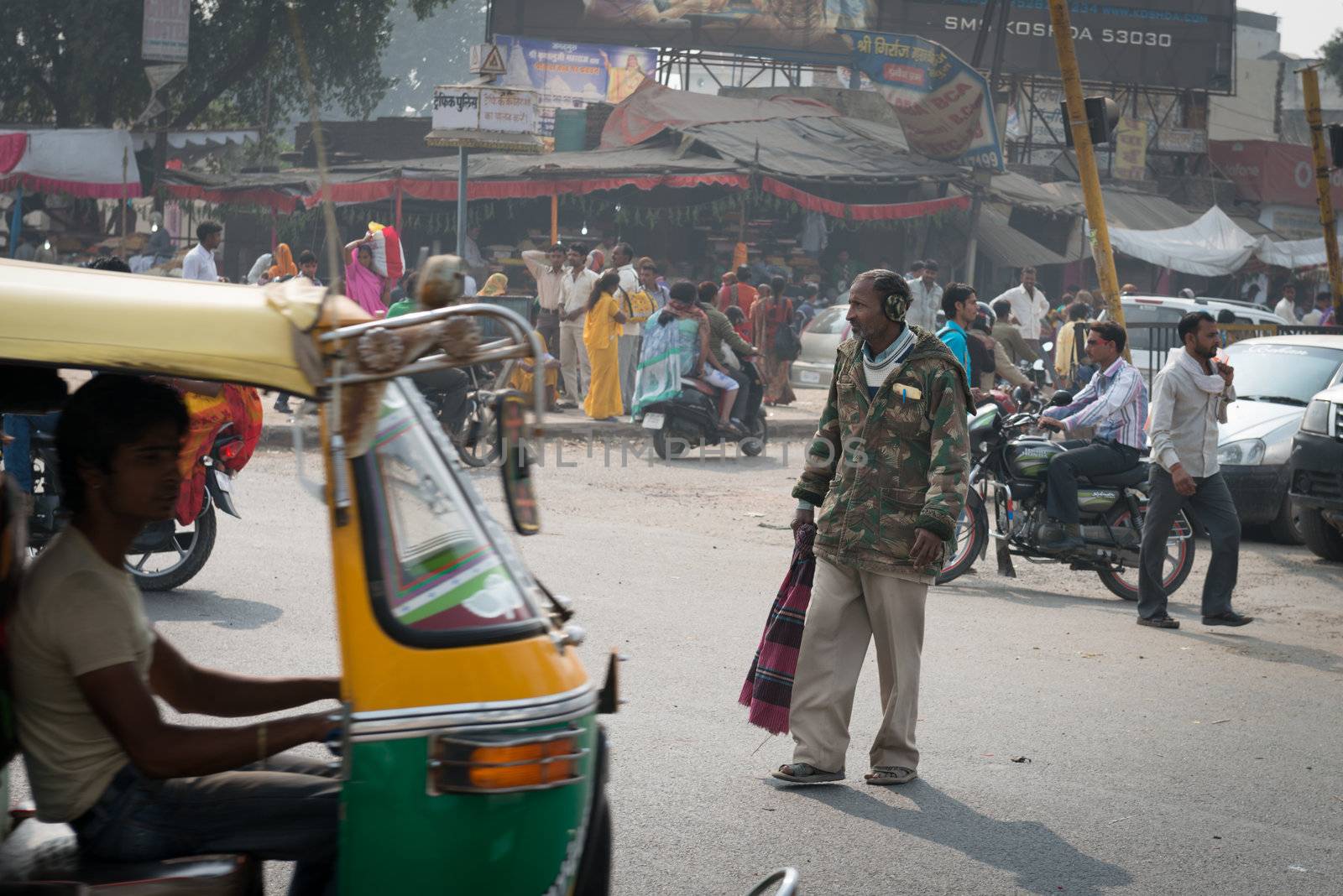  Elderly indian pedestrian in warm clothes  on typical messy cen by iryna_rasko