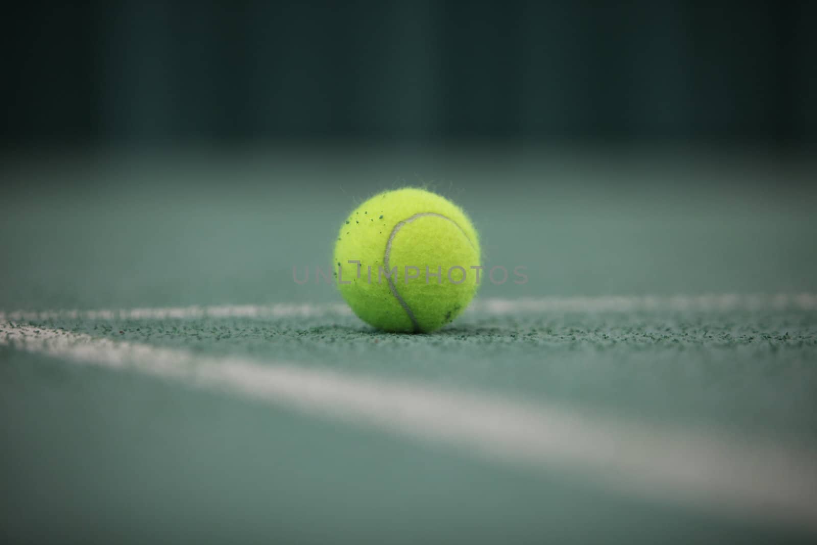 Close up of a tennis ball in the foreground, shot from low angle
