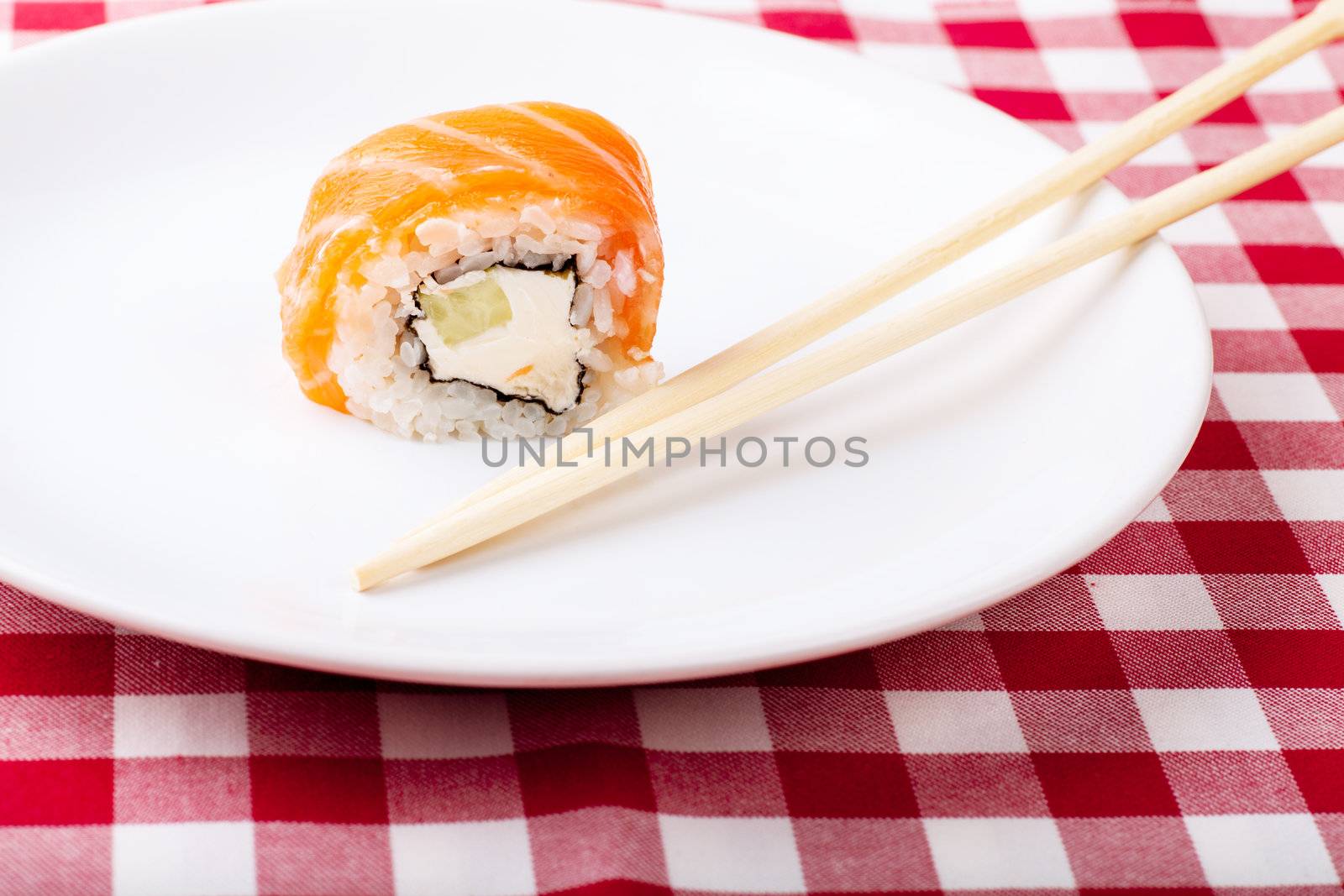 Sushi, soy and ginger with chopsticks on a white plate