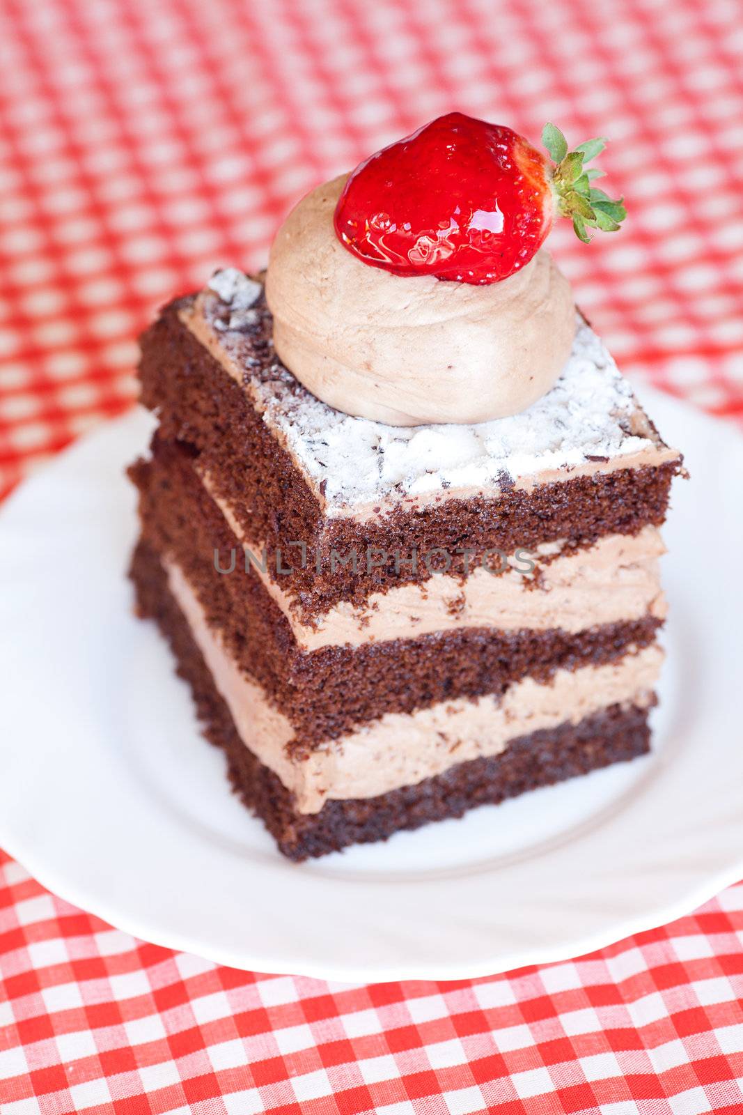 beautiful cake with strawberry on plaid fabric