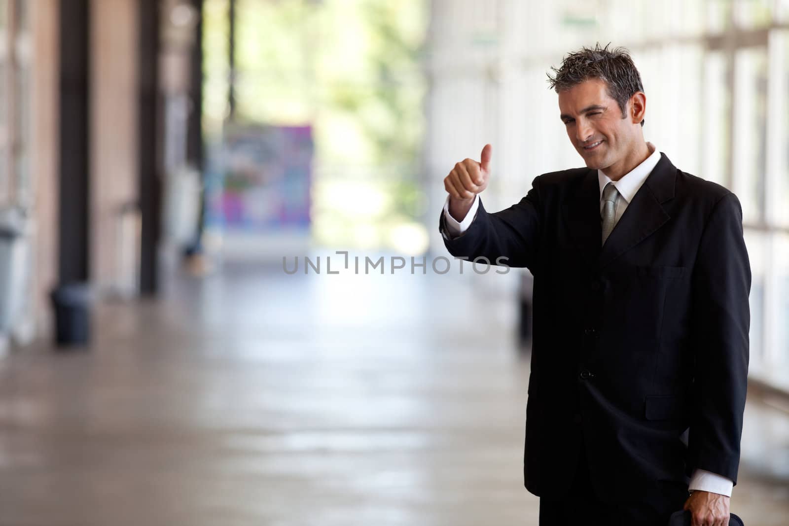 Portrait of male entrepreneur gesturing thumbs up sign