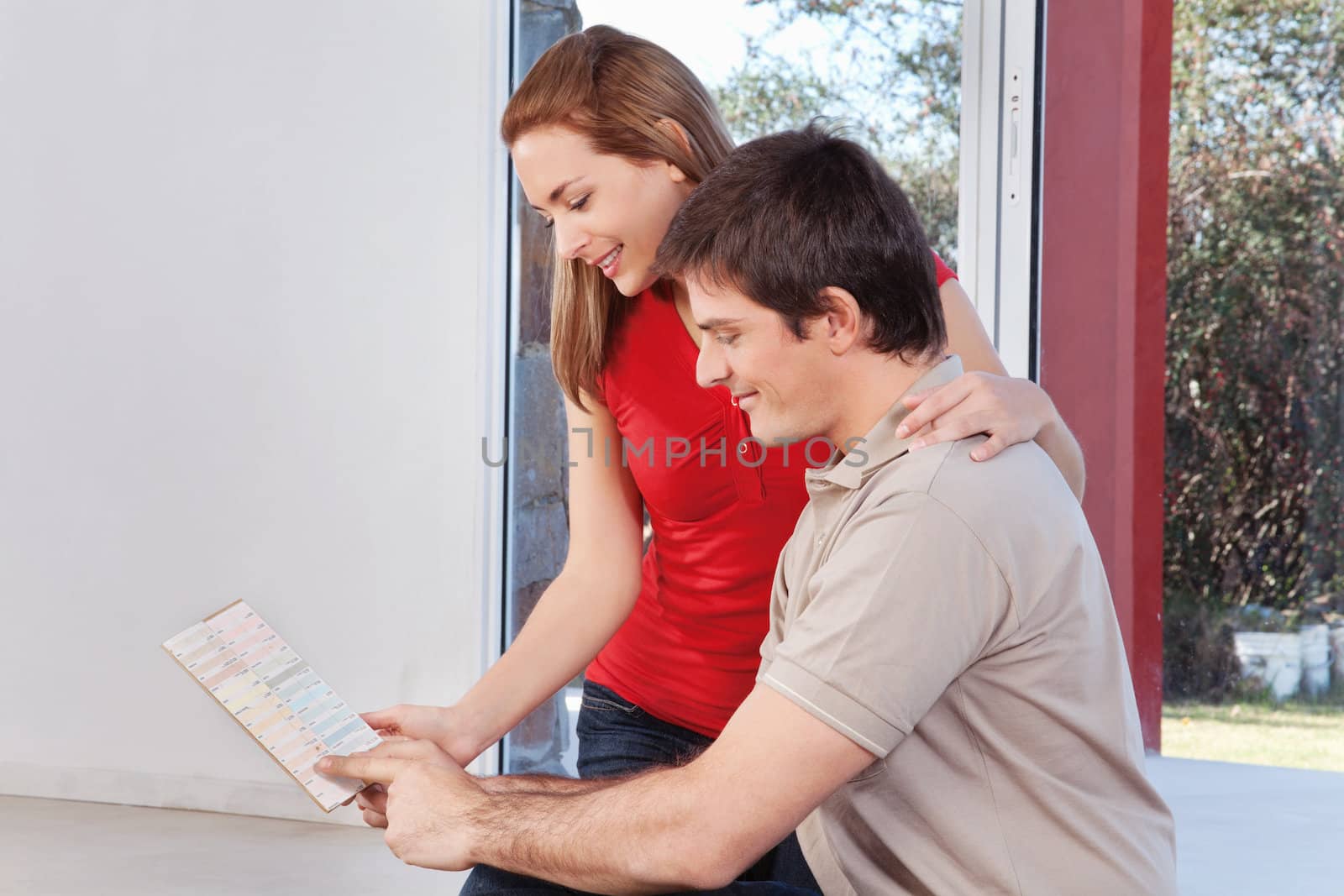 Young couple looking at color guide together in room