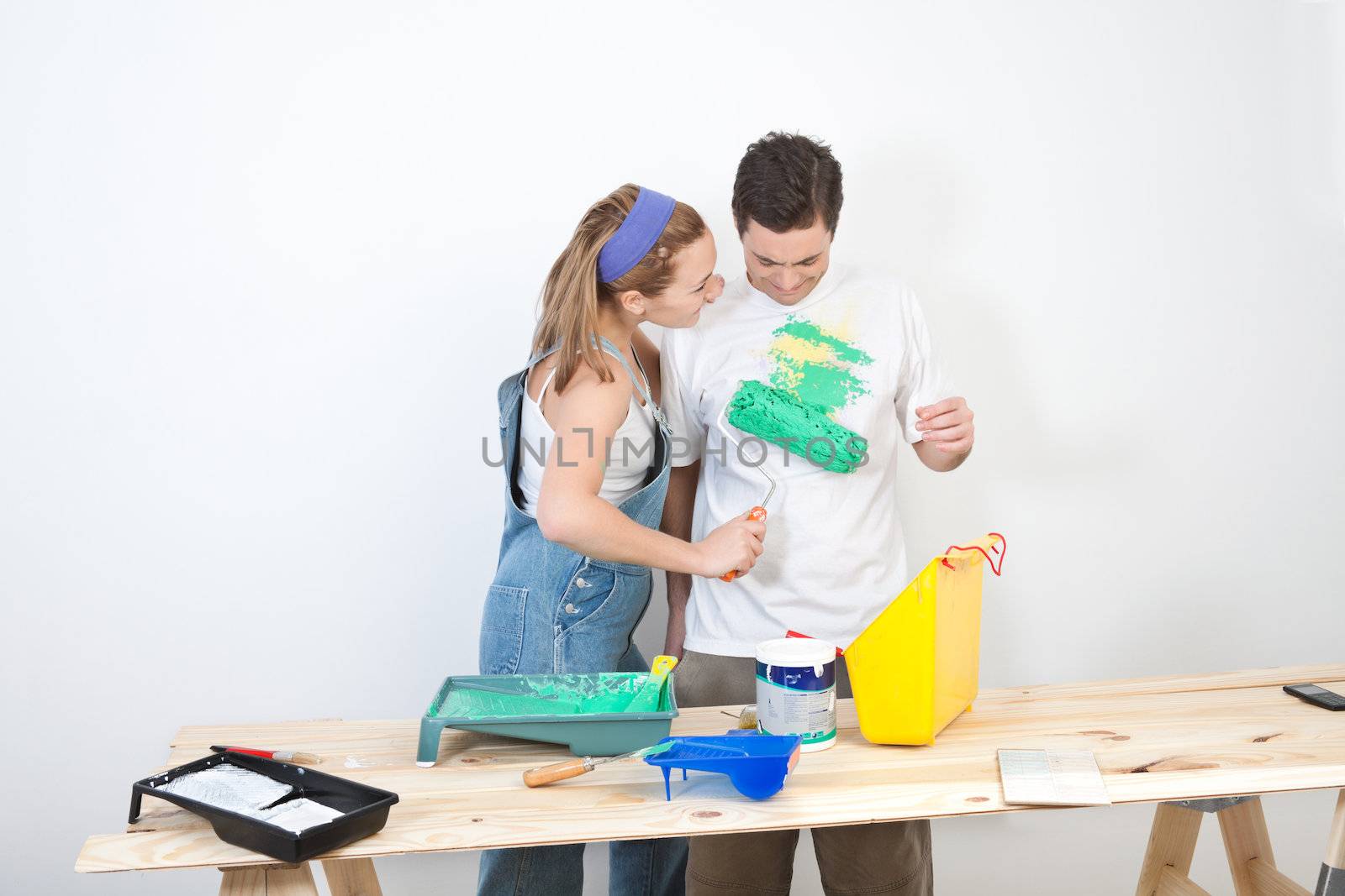 Young wife painting on t-shirt of husband