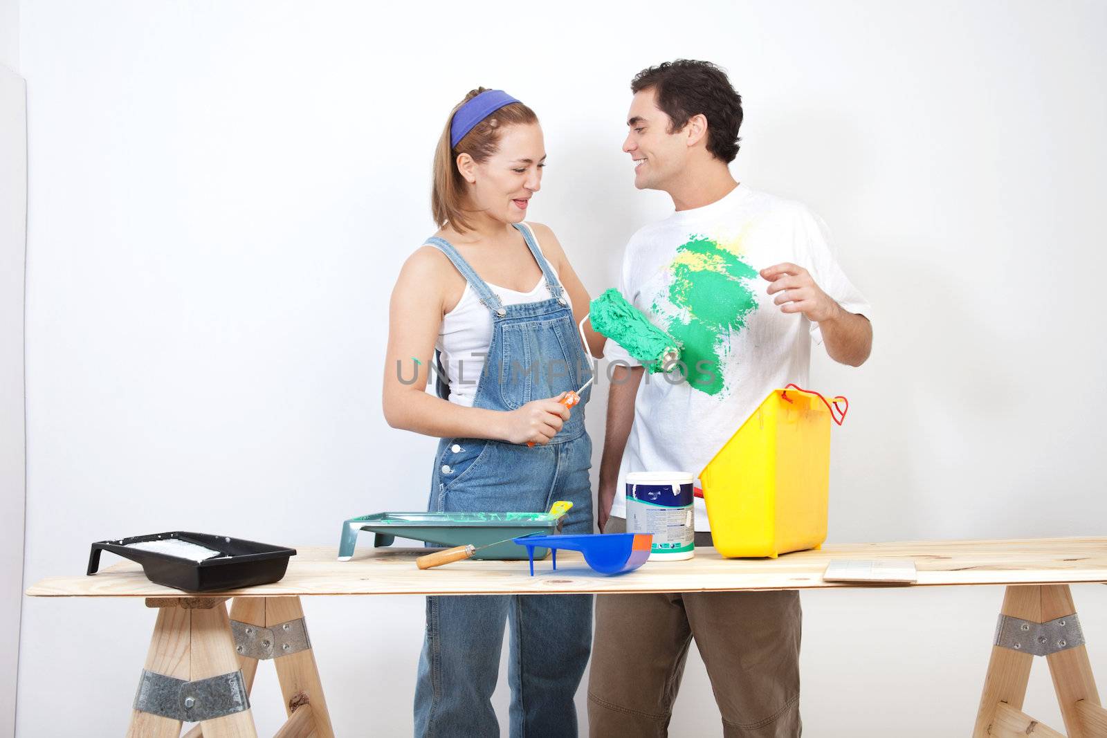 Smiling woman painting husband's t-shirt with roller