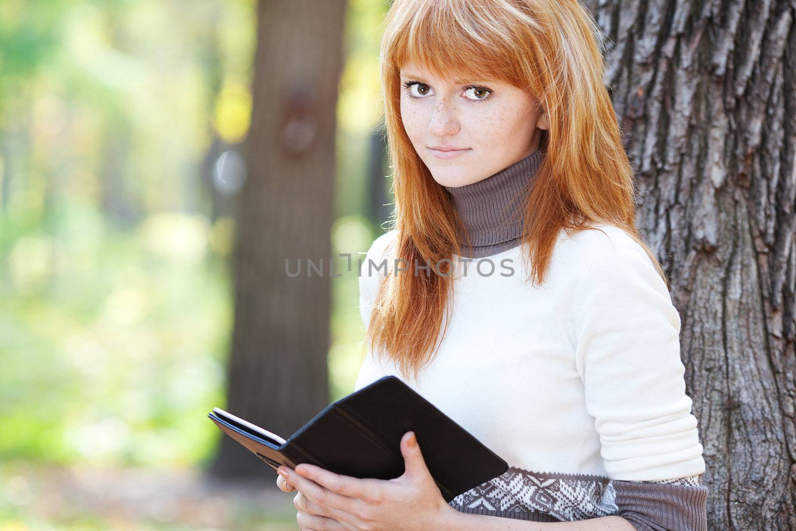 portrait of a beautiful young redhead teenager woman reading a b by jannyjus
