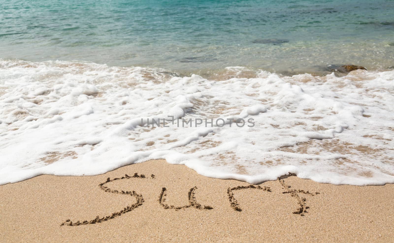 Sand drawing on warm beach by ocean surf in Caribbean spelling Surf