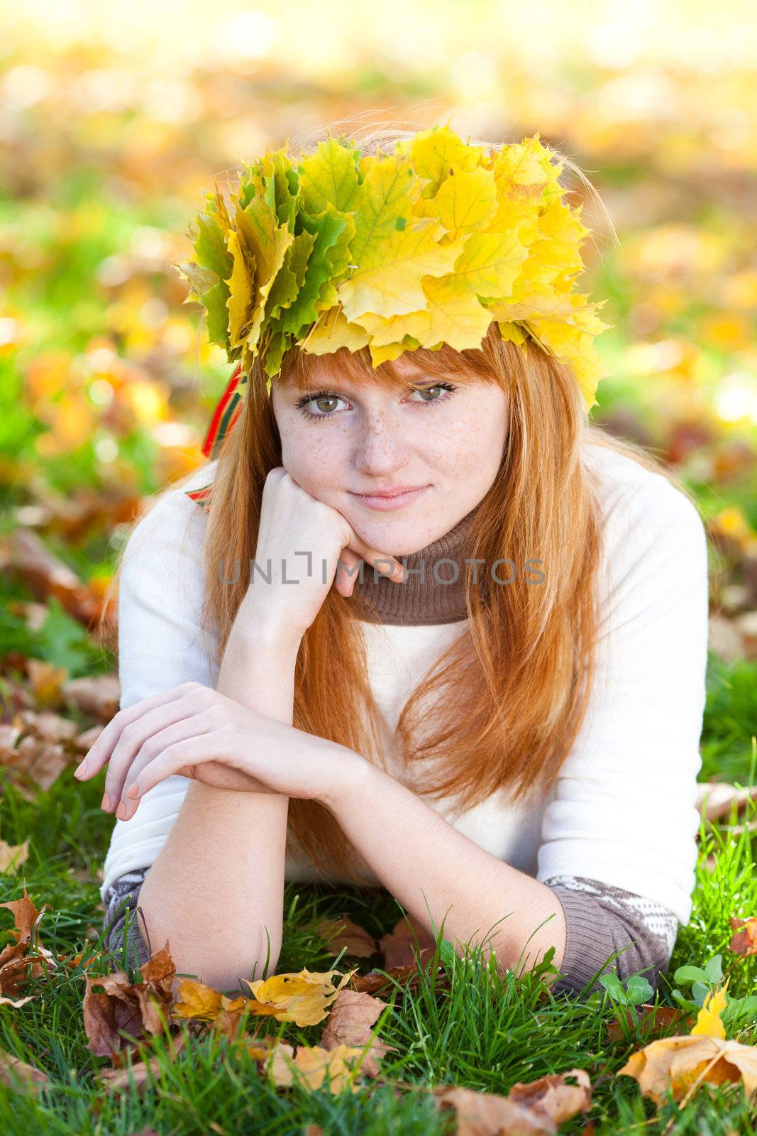 young redhead teenager woman in a wreath of maple leaves lying o by jannyjus