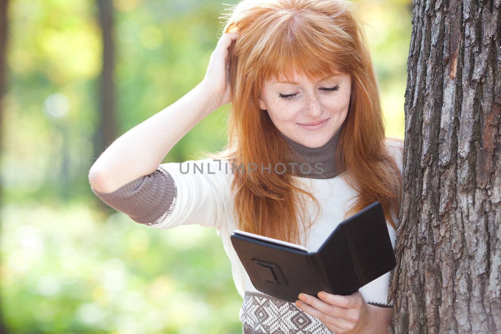 portrait of a beautiful young redhead teenager woman reading a b by jannyjus