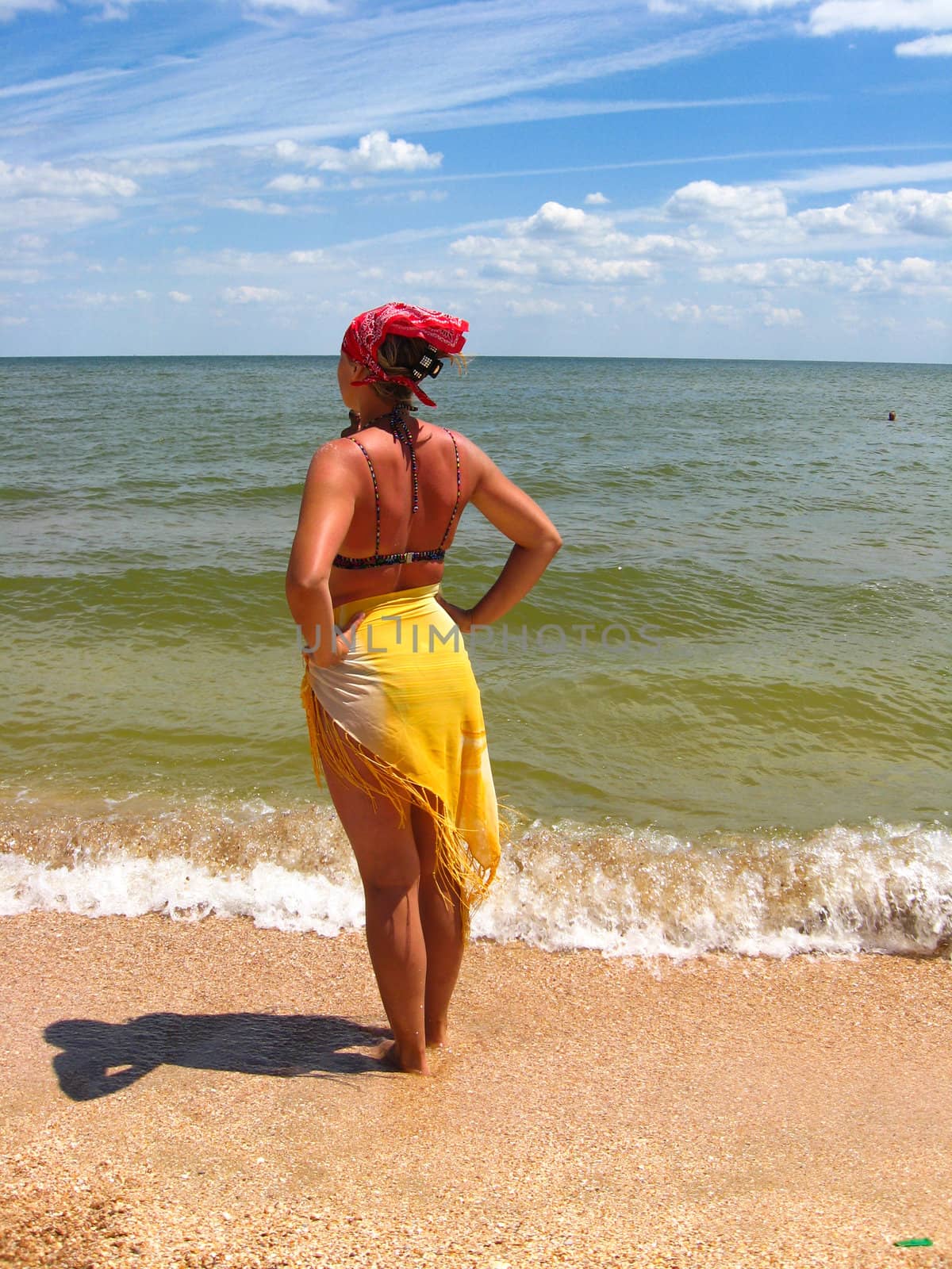 The girl in bathing suit standing at the seacoast