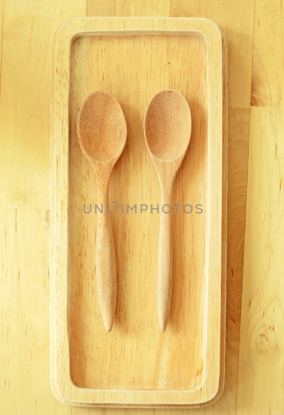 Two wooden spoons on tray by nuchylee