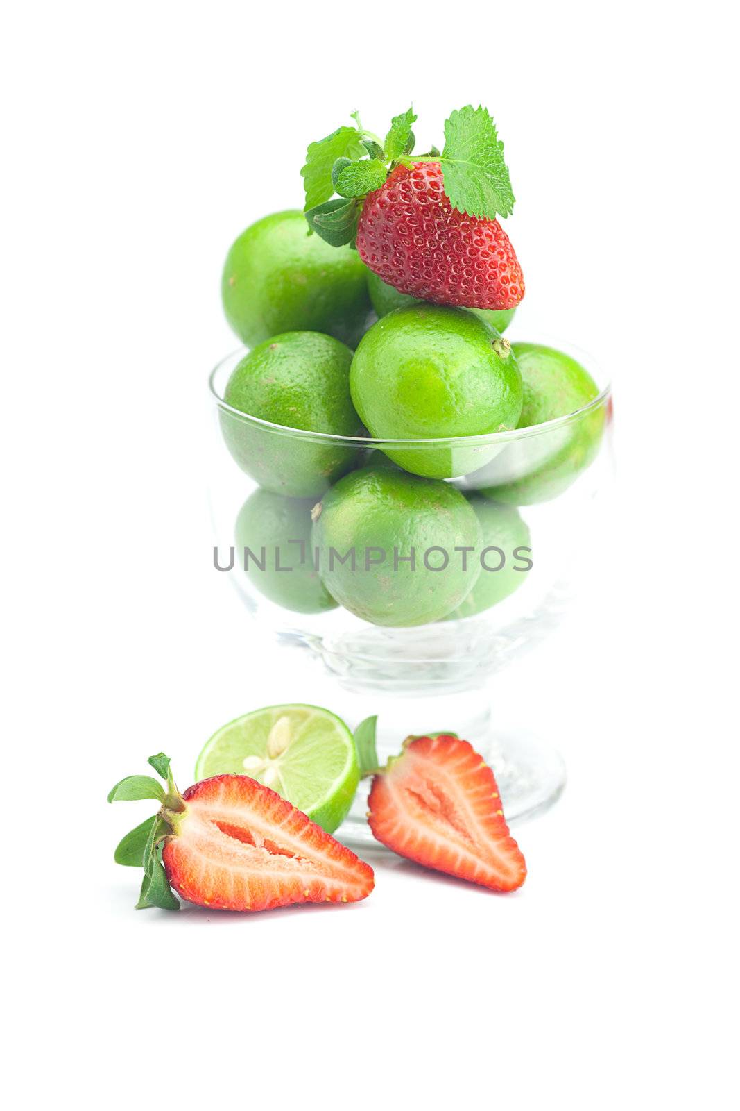 lime in a glass bowl, strawberry and mint isolated on white
