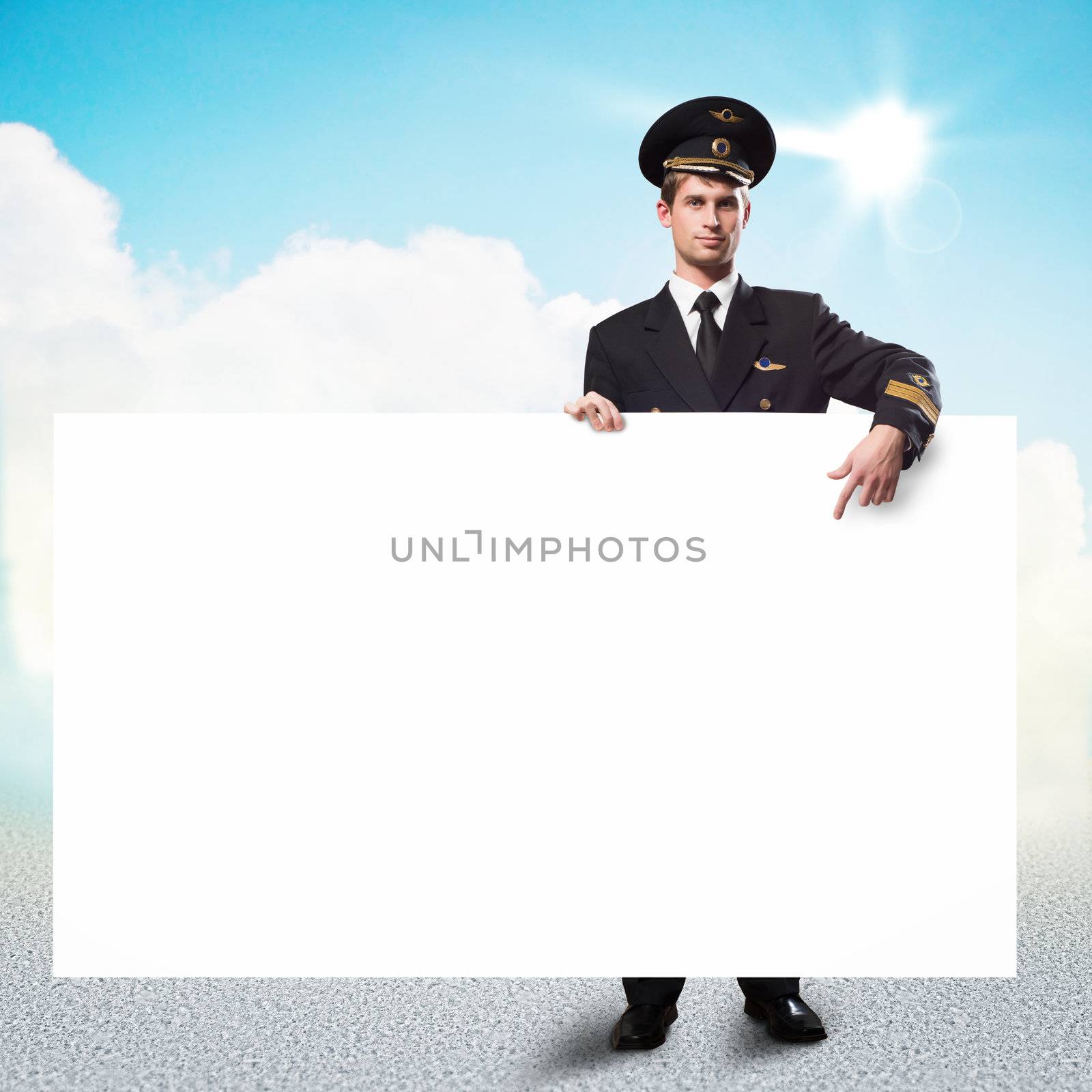 pilot in the form of holding an empty billboard on the background of sky with clouds, place for text