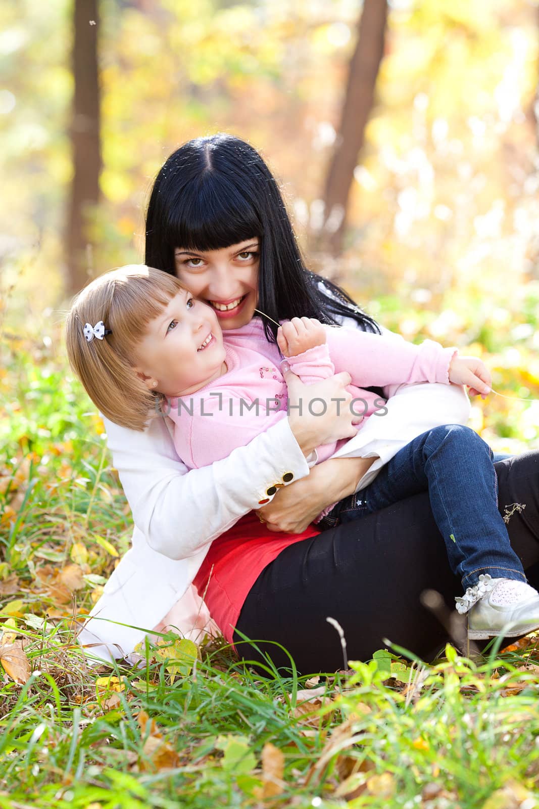 beautiful young mother and her daughter on the autumv forest